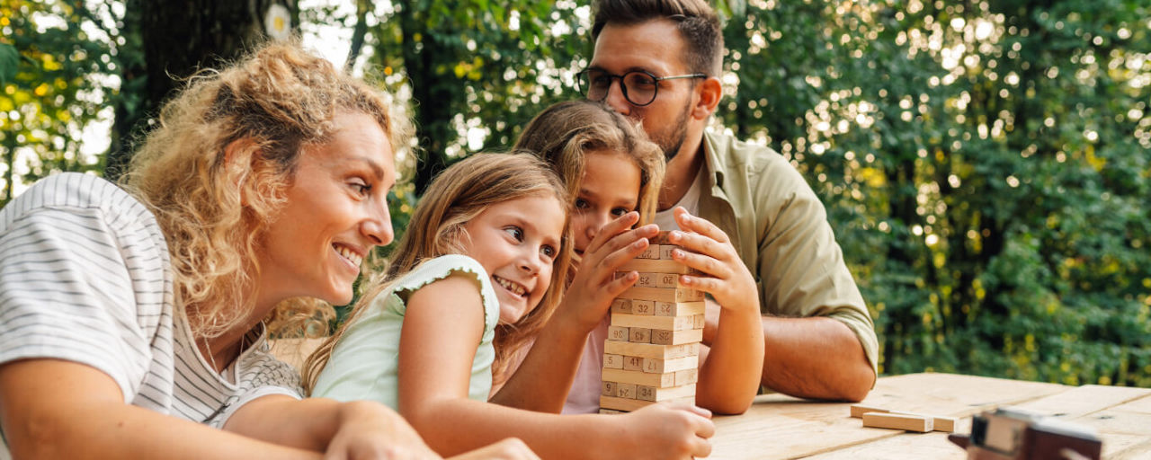 Familie spielt draußen Stapelturm.