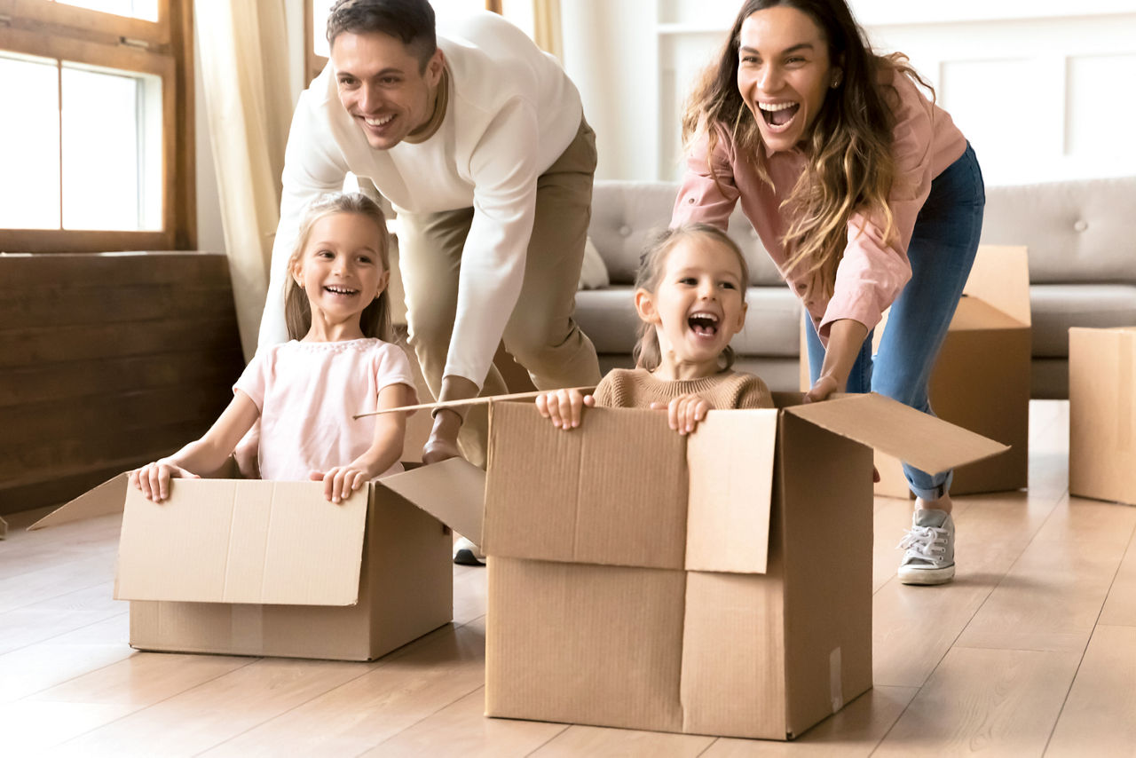 Familie spielt mit Kindern und Umzugskartons