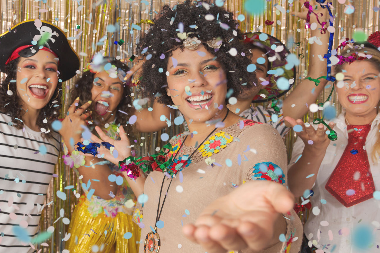 Bild zeigt verkleiderte Leute die Konfetti werfen.