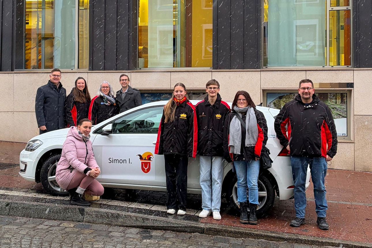 Gruppenbild mit einem Auto Mitarbeiter der VR Dachau und der Faschigsgesellschaft Dachau