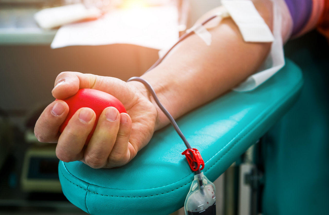 Blood donor at donation with bouncy ball holding in hand