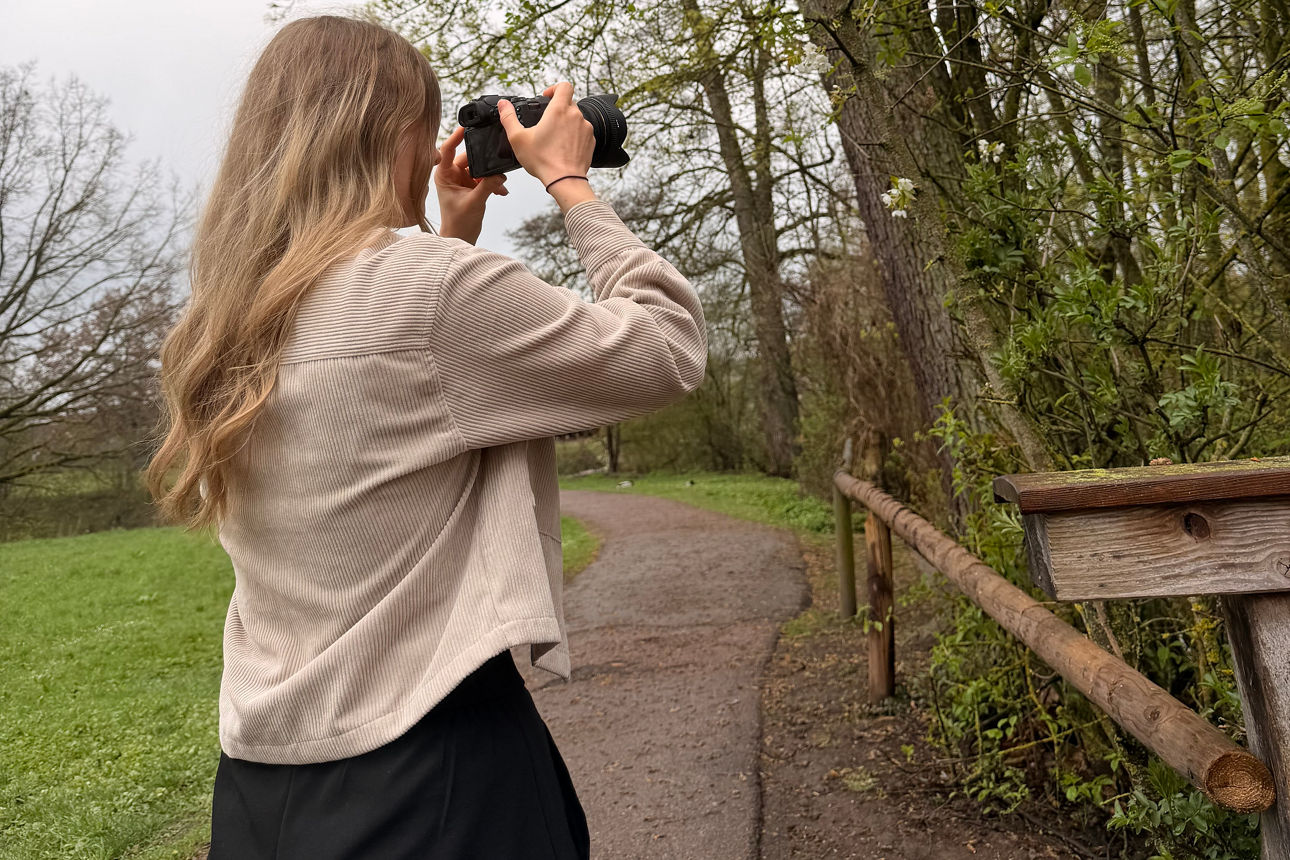 Junge Frau fotografiert einen Baum