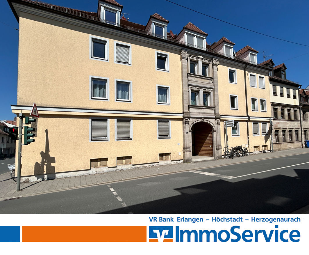 Mehrfamilienhaus mit gelber Fassade an einer Kreuzung