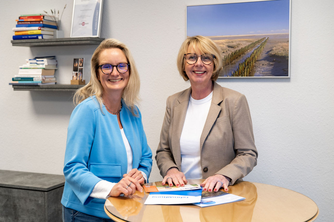 Mitarbeiterinnen schauen gemeinsam in einen Prospekt