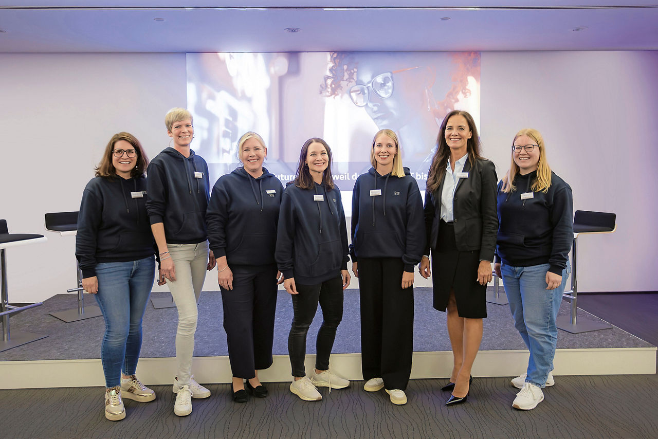 Vertreterinnen des Frauennetzwerks der VerbundVolksbank OWL und Vorständin Ina Kreimer stehen im Veranstaltungsraum