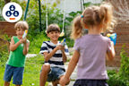 Kinder die im Garten mit Wasserpistolen spielen 