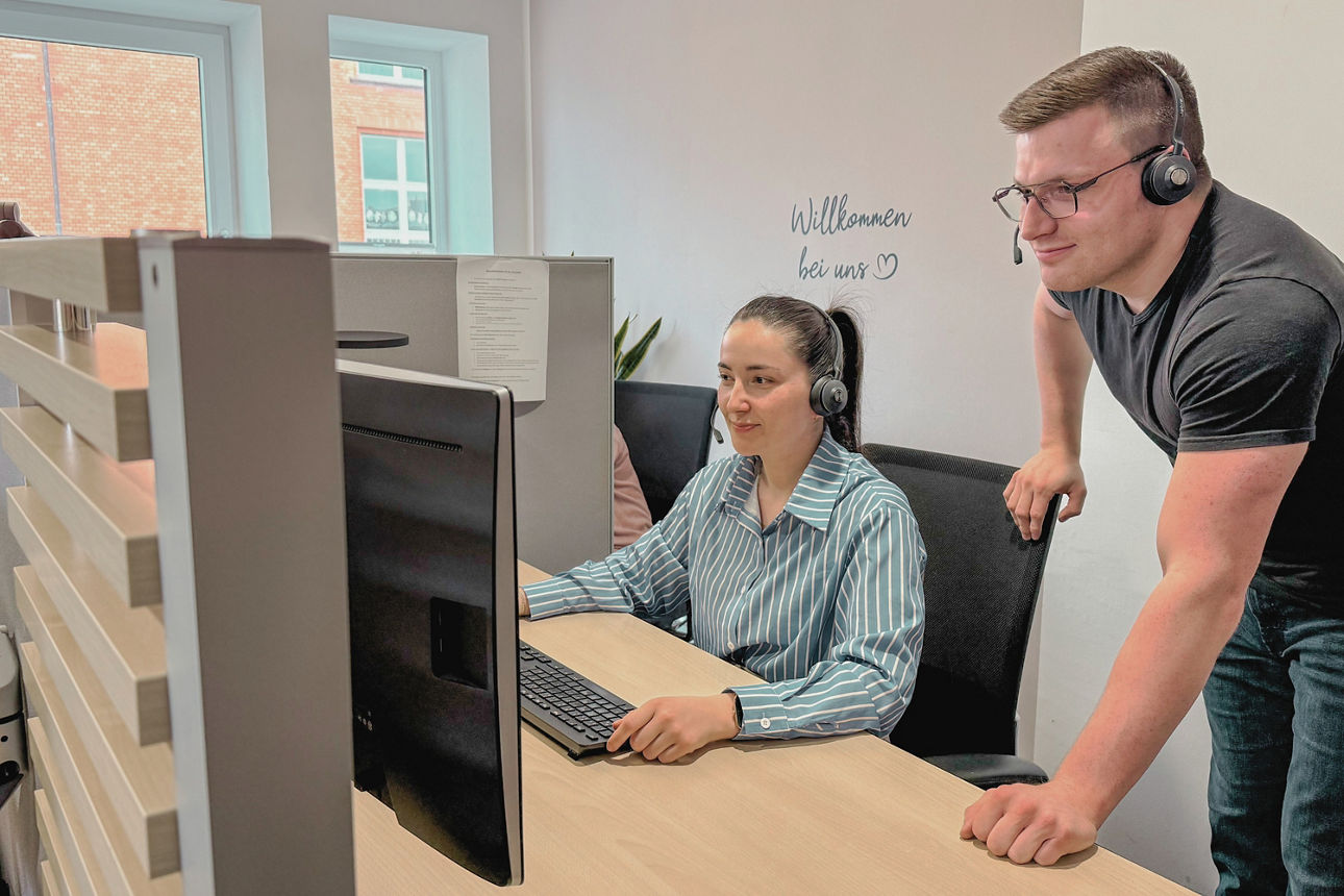 Ein Mann und eine Frau schauen auf einen Monitor