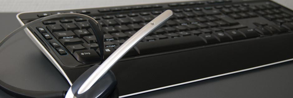 Eine schwarze Tastatur mit einem silbernen Headset