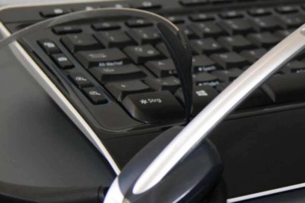 Eine schwarze Tastatur mit einem silbernen Headset