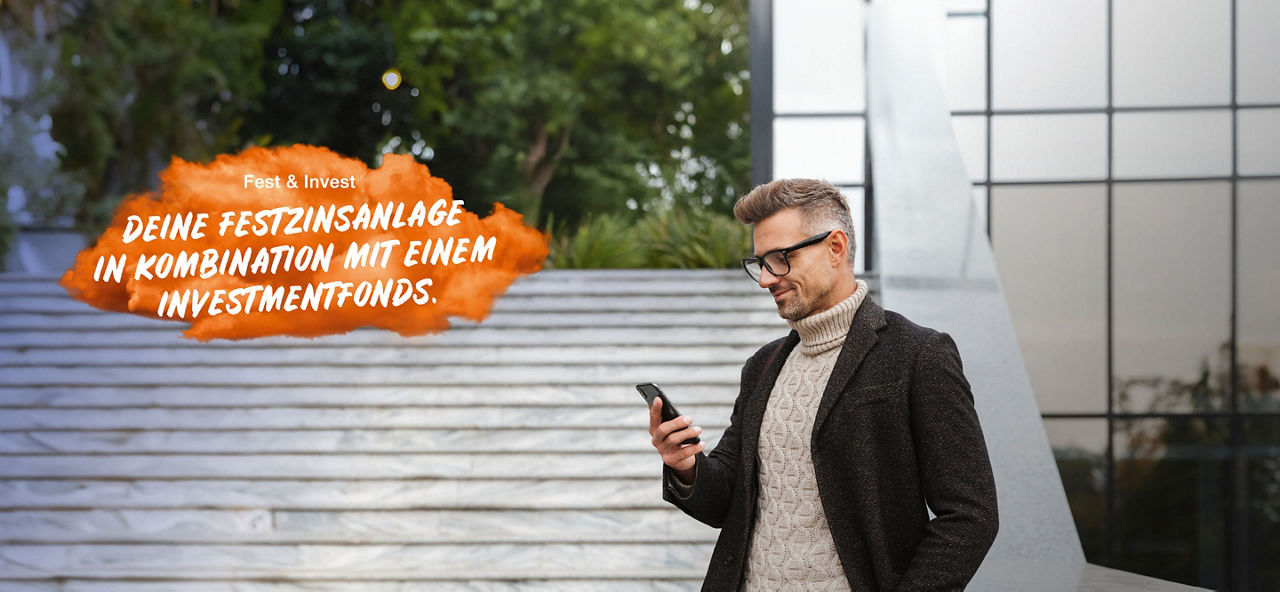 Junger lächelnder Mann mit Brille und einem schwarzen Mantel steht neben einer hellen Steintreppe und  schaut in sein Smartphone. Links im Bild steht auf einer orangenen Fläche "Fest & Invest: Deine Festzinsanlage in Kombination mit einem Investmendfonds."