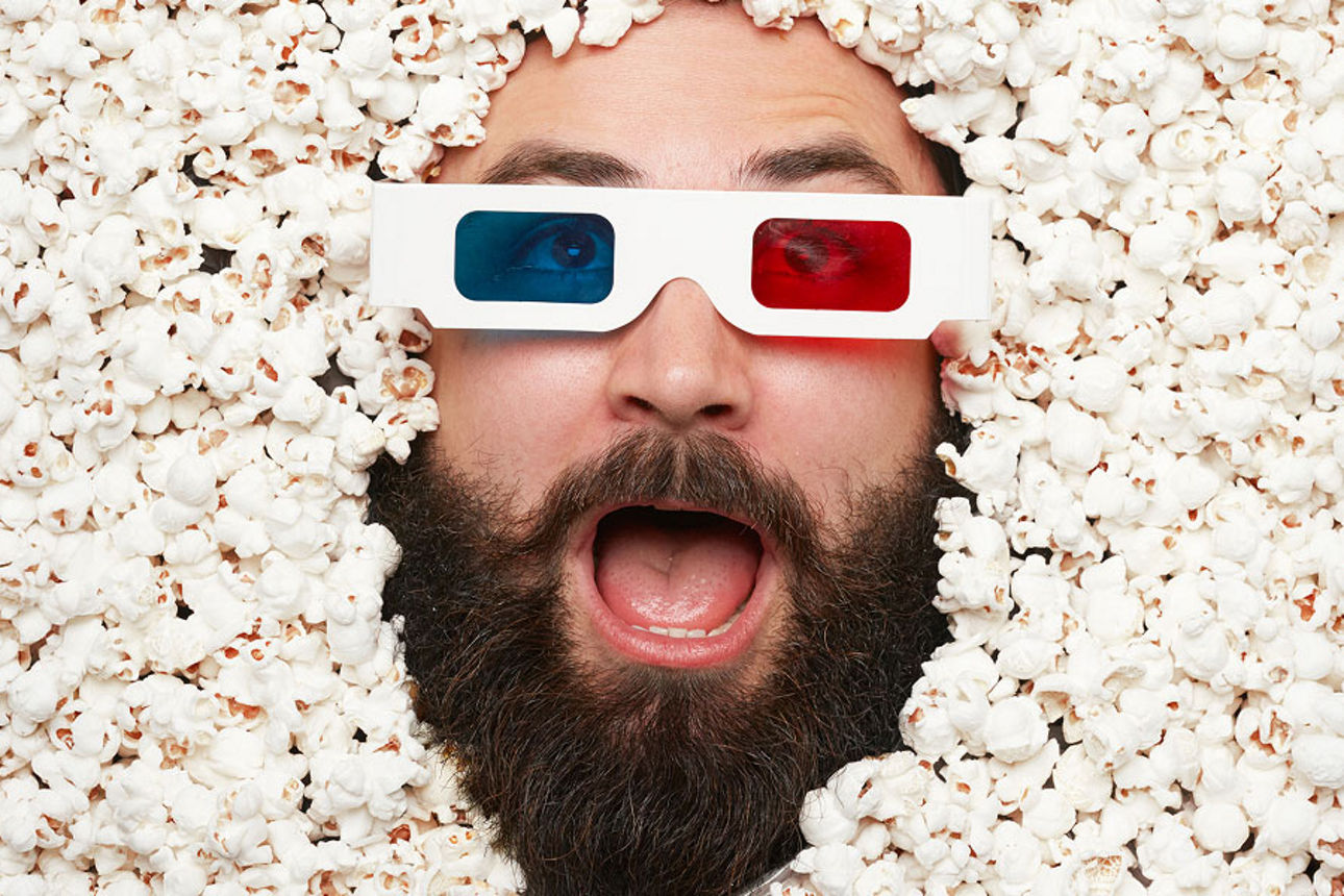 Mann liegt mit einer 3D-Brille zwischen Popcorn