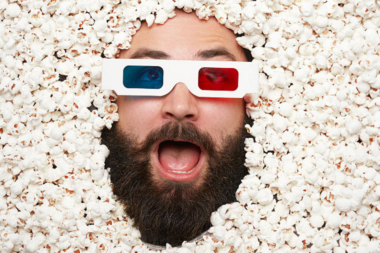 Mann liegt mit einer 3D-Brille in Popcorn