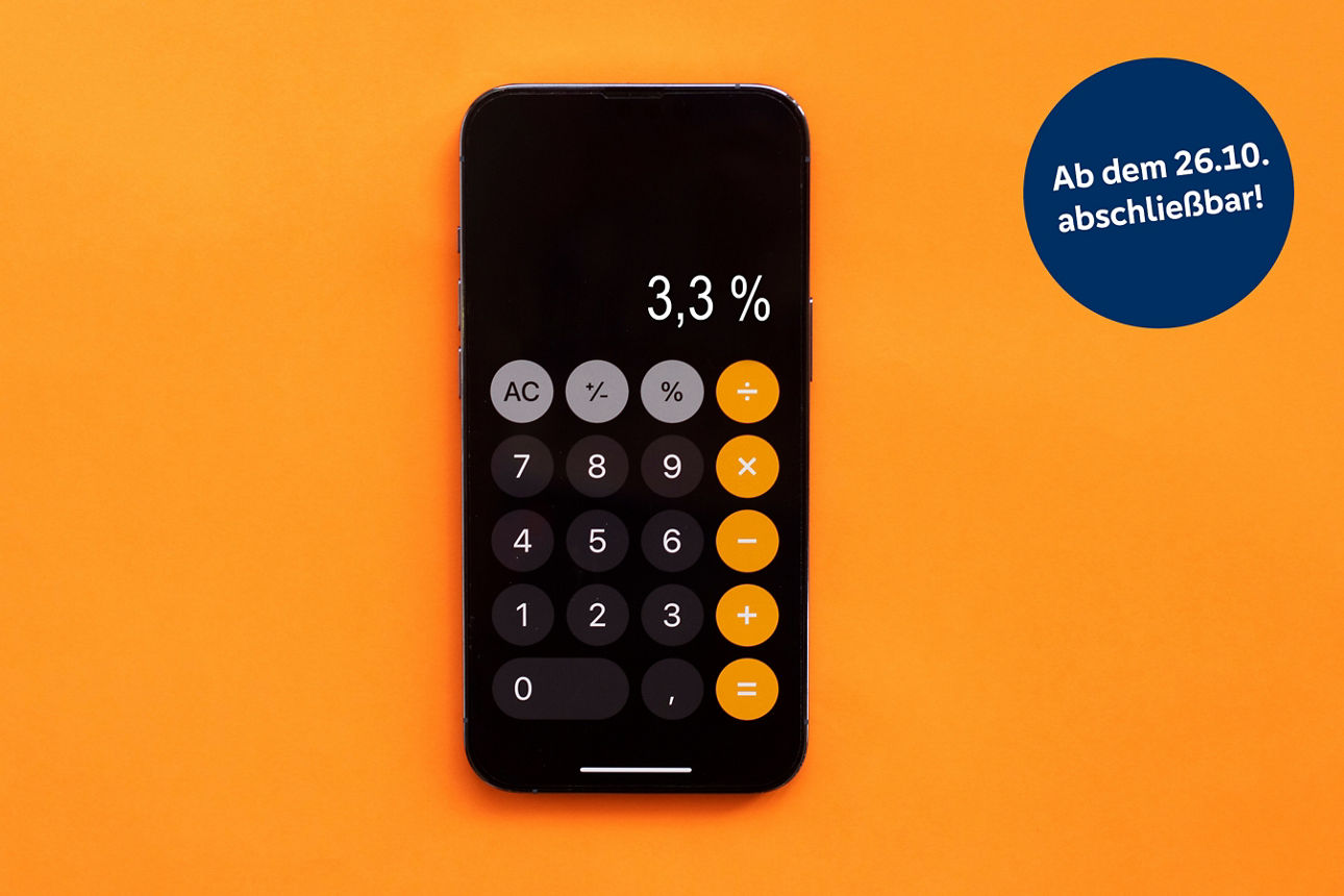 Smartphone mit geöffneter Taschenrechner-App und Anzeige von 3,3 Prozent vor orangefarbenem Hintergrund