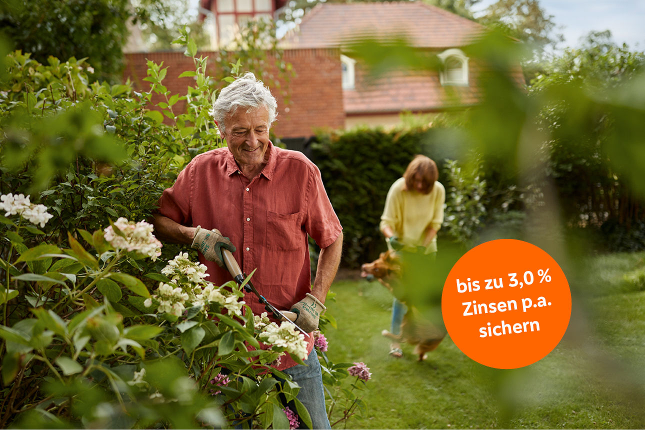 Zwei Personen pflegen einen Garten mit Blumen und Sträuchern; orangefarbener Zinshinweis rechts unten.