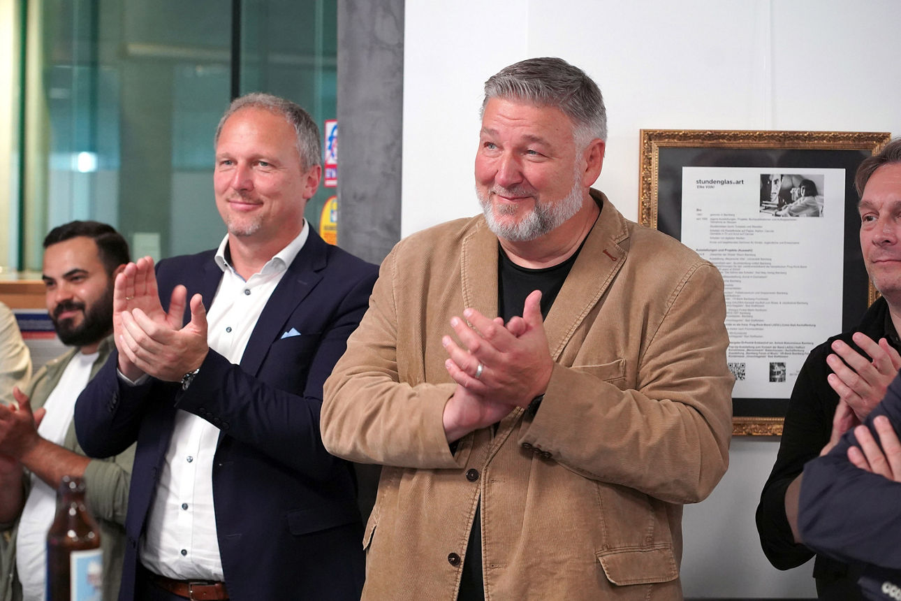 Filialbereichsleiter Stefan Wolfschmidt und Klaus Stieringer (Stadtmarkteting Bamberg) applaudieren