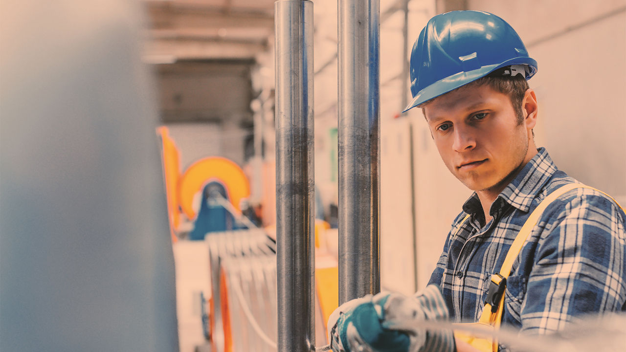 Geschäftsleitung und Bankberater im Gespräch an einer Produktionsstätte