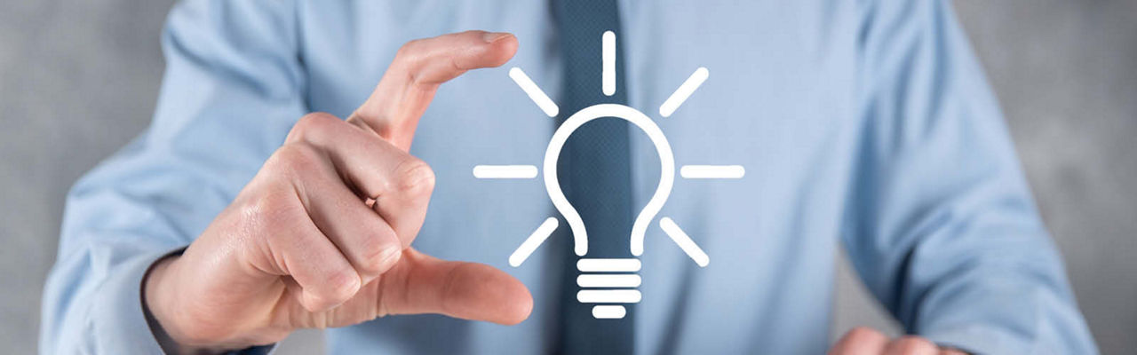 Geschäftsmann hält eine Glühbirne über seiner Hand, die Innovation symbolisiert