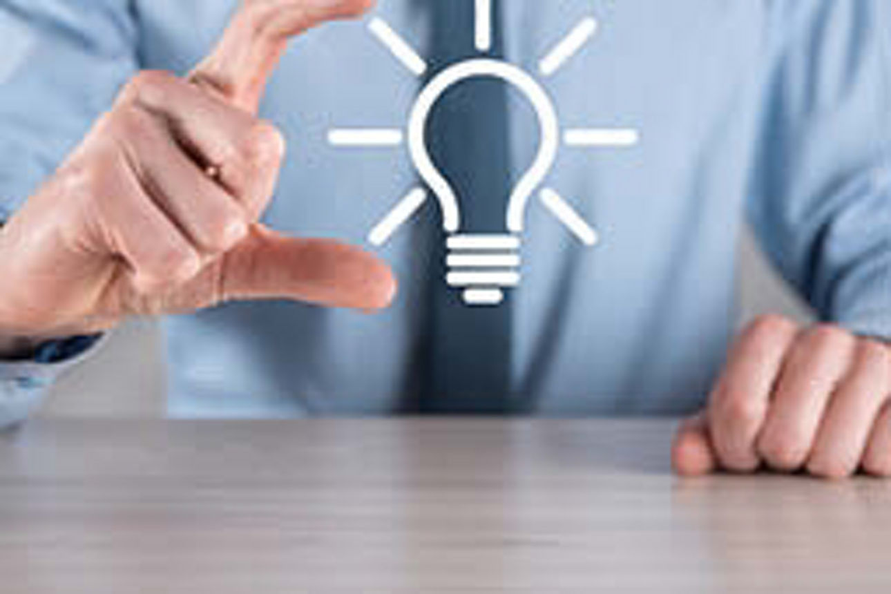 Geschäftsmann hält eine Glühbirne über seiner Hand, die Innovation symbolisiert