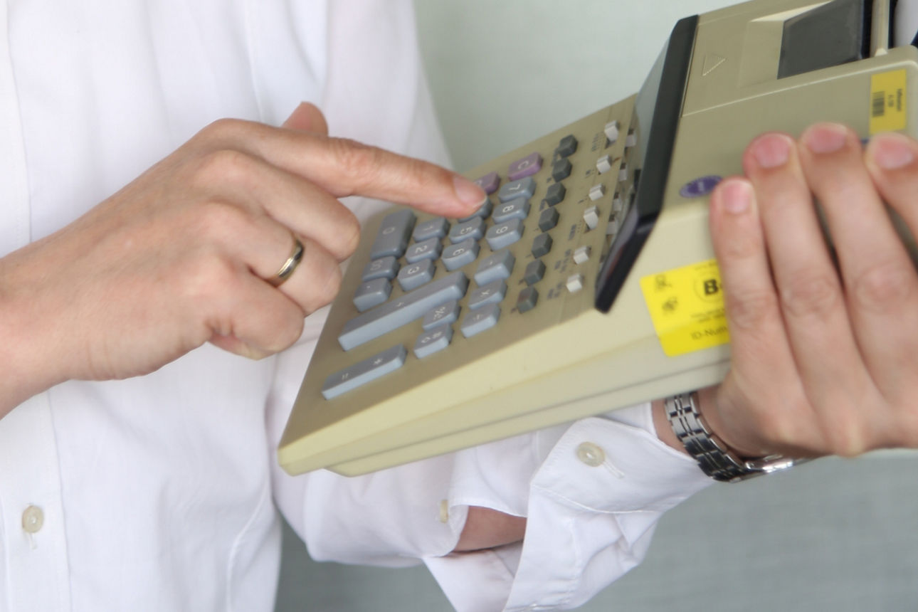 Finger tippt auf Rechenmaschine