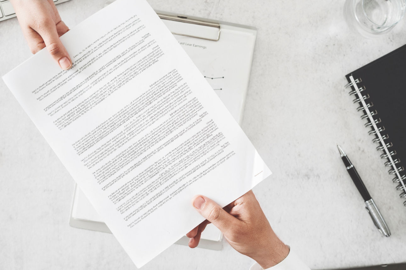 2 Personen mit einem Dokumentenvertrag in den Händen