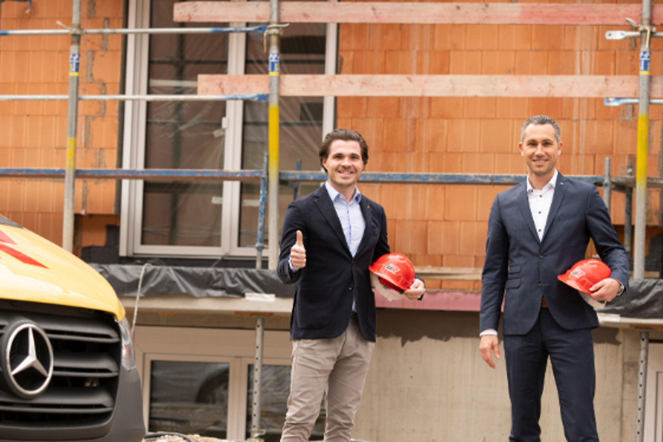 Firmenkundenberater ist mit Bauunternehmer auf der Baustelle