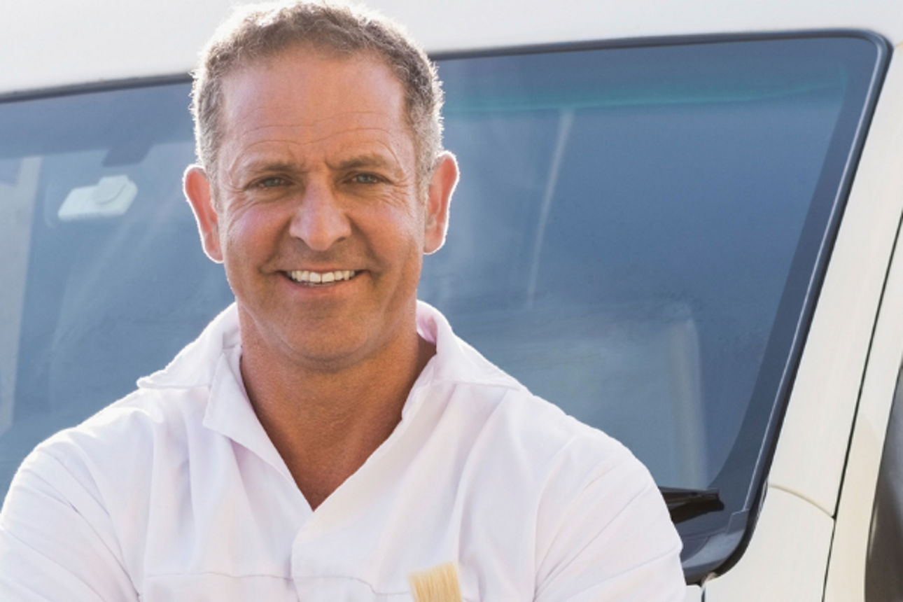 Maler vor Auto in das ein anderer etwas einlädt