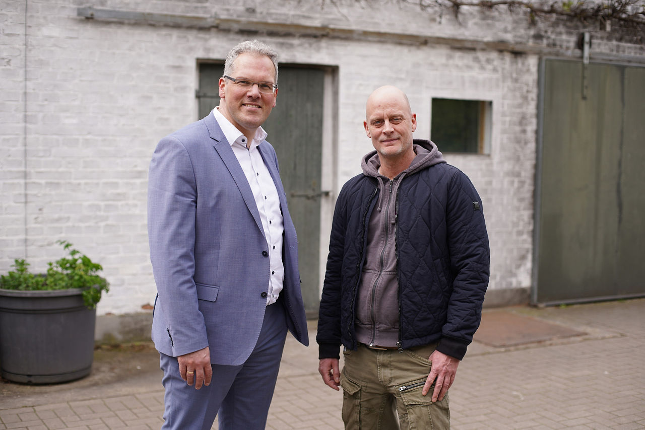 Firmenkundenberater und Kunde stehen vor einem Gebäude