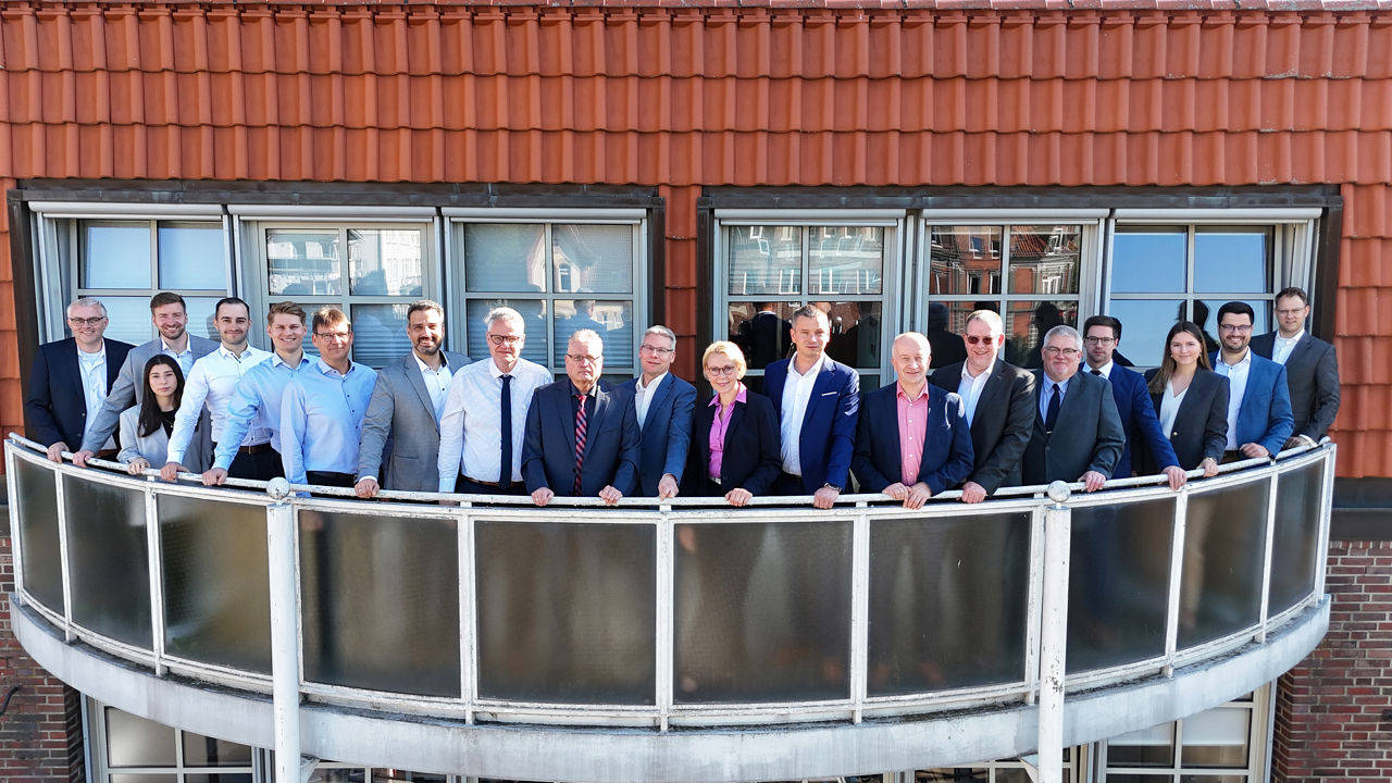 Firmenkundenteam der Volksbank Uelzen-Salzwedel steht auf dem Balkon und schaut in die Kamera