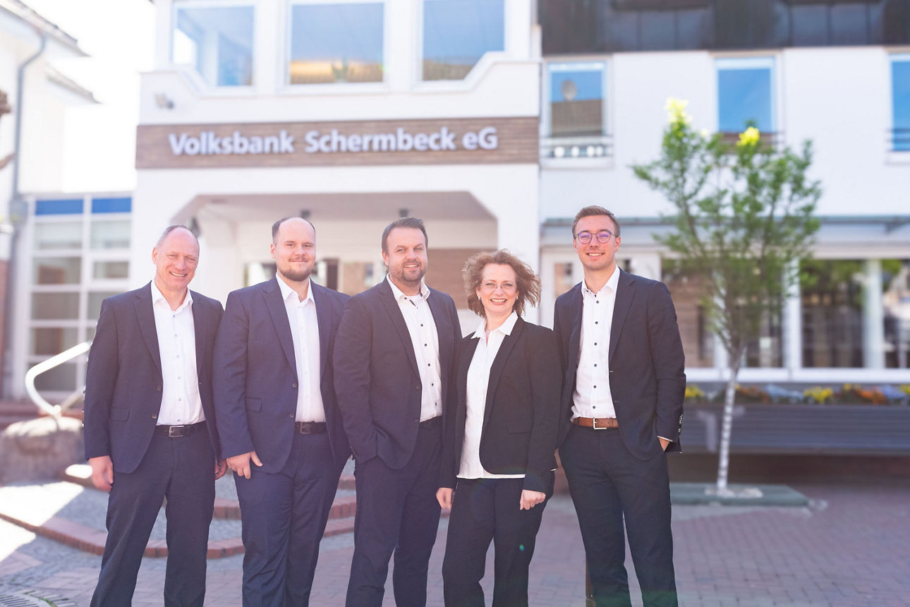 Vier Männer und eine Frau stehen vor dem Haupteingang der Volksbank Schermbeck
