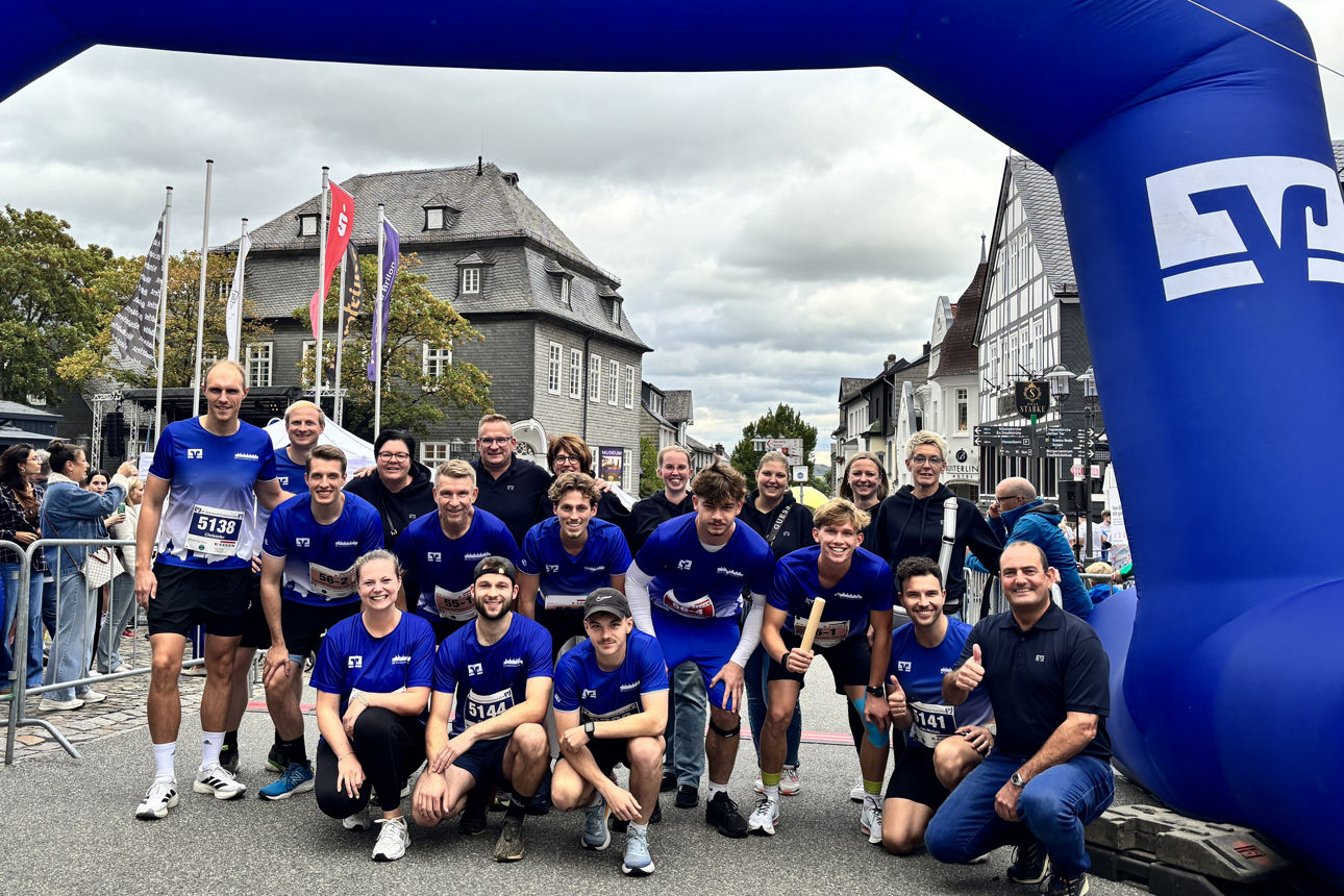 Das Team der Volksbank Brilon steht unter dem Zieleinlauf beim Volksbank-Firmenlauf.