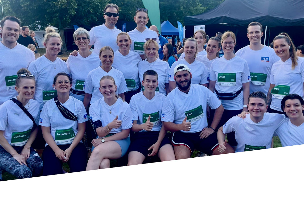 Viele Mitarbeitende der Volksbank Bochum Witten eG lächeln vor dem Firmenlauf in die Kamera