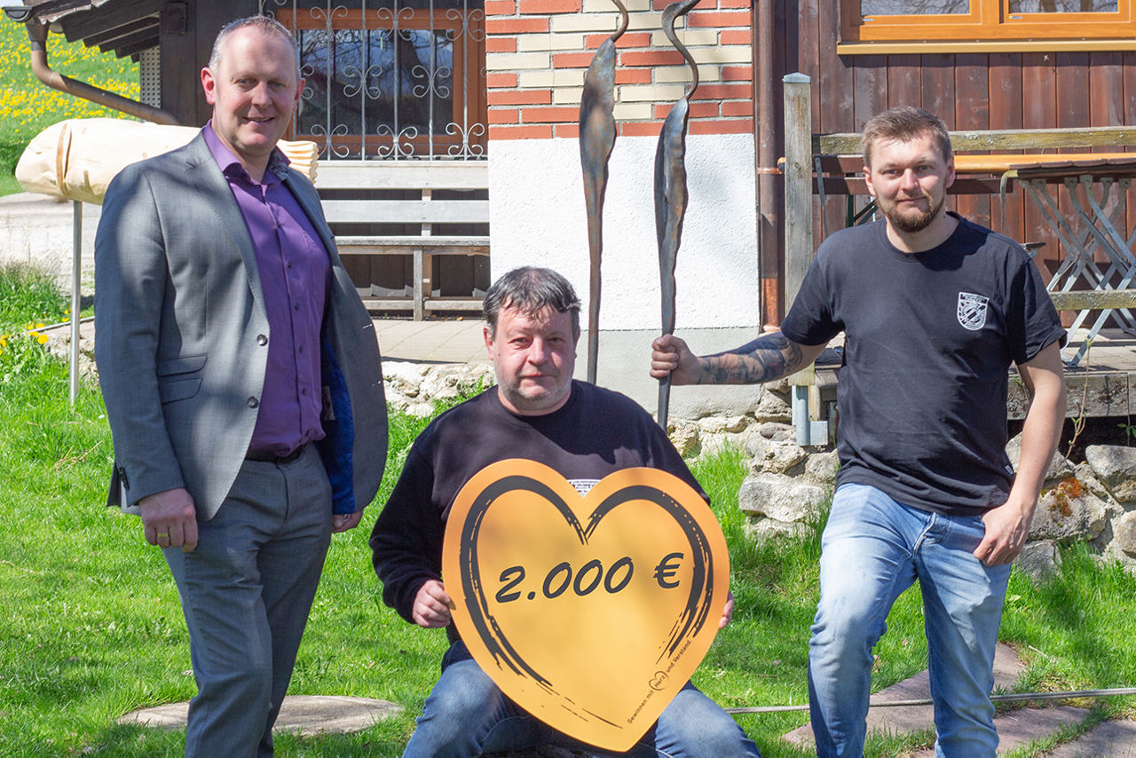 Unser Vorstand mit den Vorständen des Fischereivereins vor dem Vereinshaus mit orangenem Herzen in der Hand.