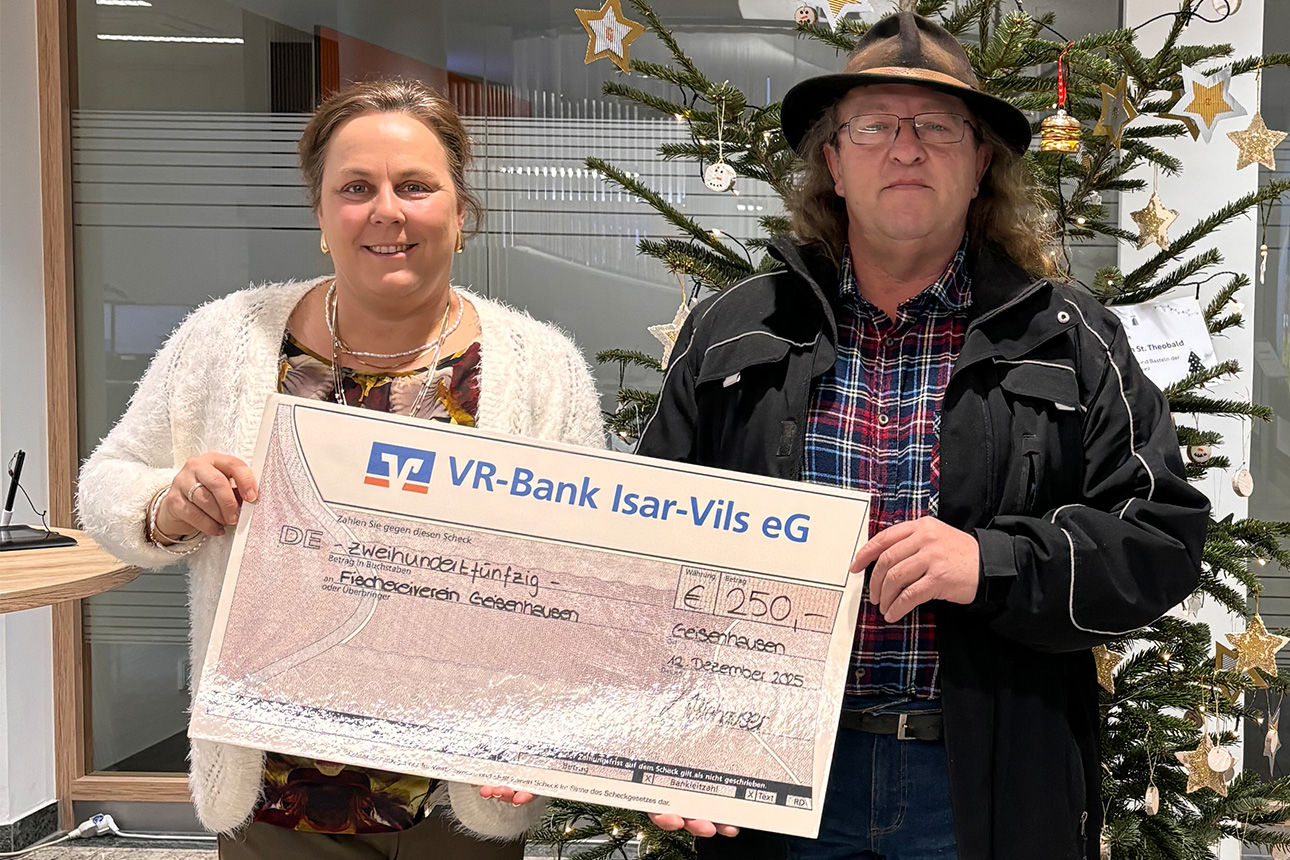 Eine Frau und ein Mann lächeln in die Kamera. Sie halten einen Riesenspendenscheck in der Hand.