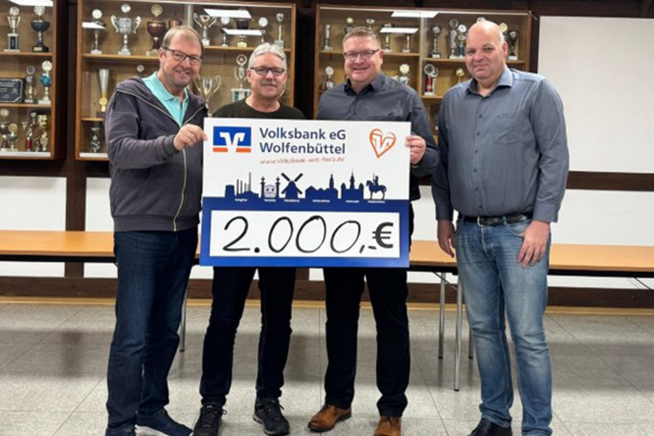 Vier Männer halten ein großes Schild