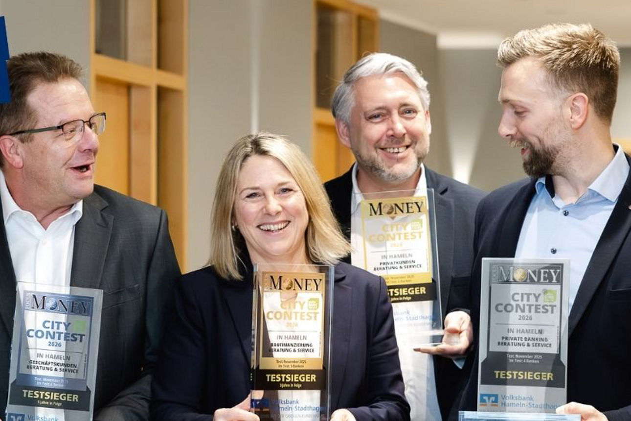 Vier Personen, Führungskräfte unserer Bank, präsentieren freudig die erhaltenen Auszeichnungen.