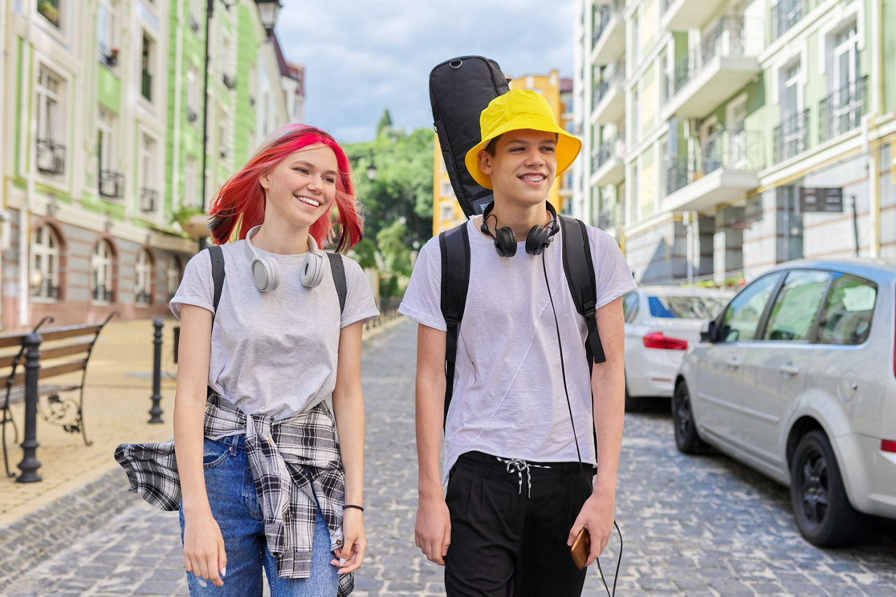 Jugendliches Mädchen und Junge laufen auf einer Straße