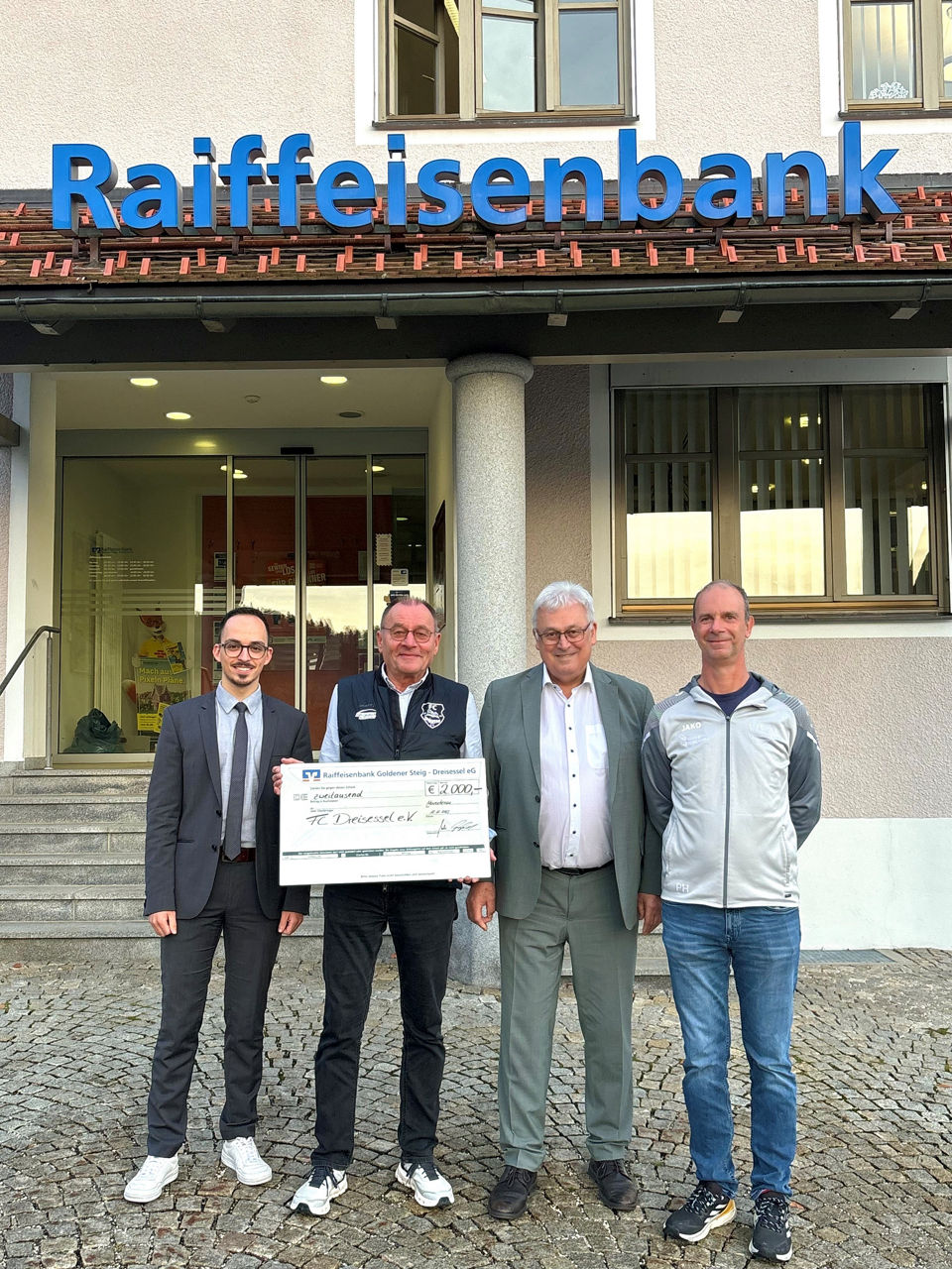 Scheckübergabe vor Bank mit Bauer Dominik, Heinz Strobl, Erich Mertl und Peter Helfensteller