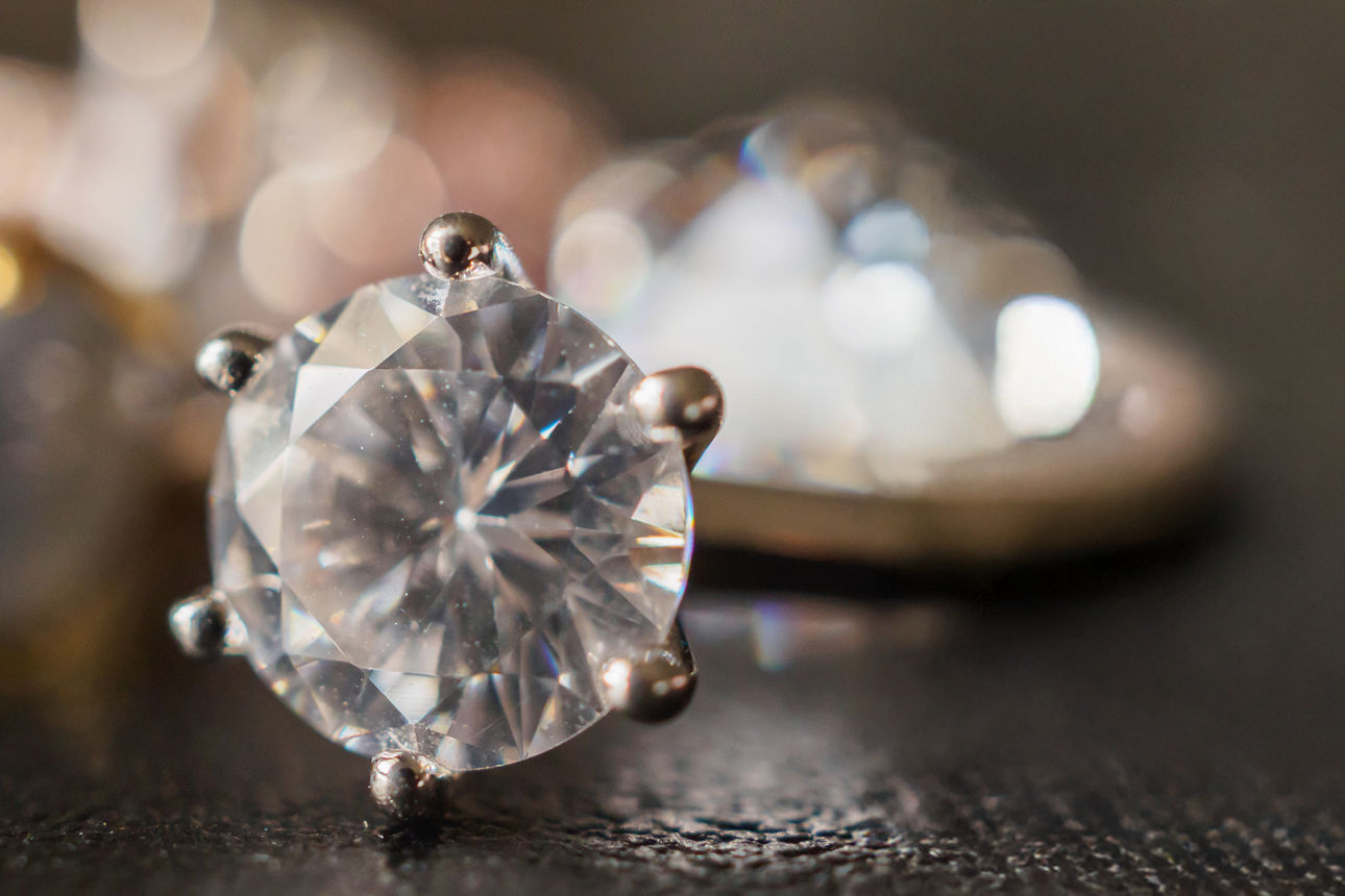 Ring mit einem Diamanten auf einem dunklen Hintergrund.