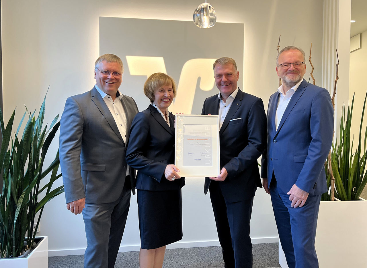 Evelyn Leipold überreicht die Urkunde „Premium-Partner Förderberatung“ an die Volksbank im Münsterland