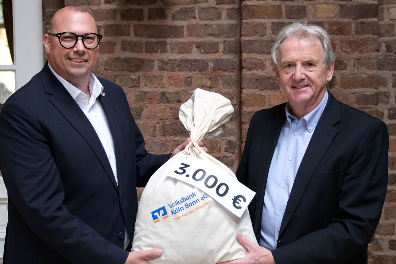 Frederick Geitel (Volksbank Köln Bonn eG) und Willi Wester bei der Spendenübergabe