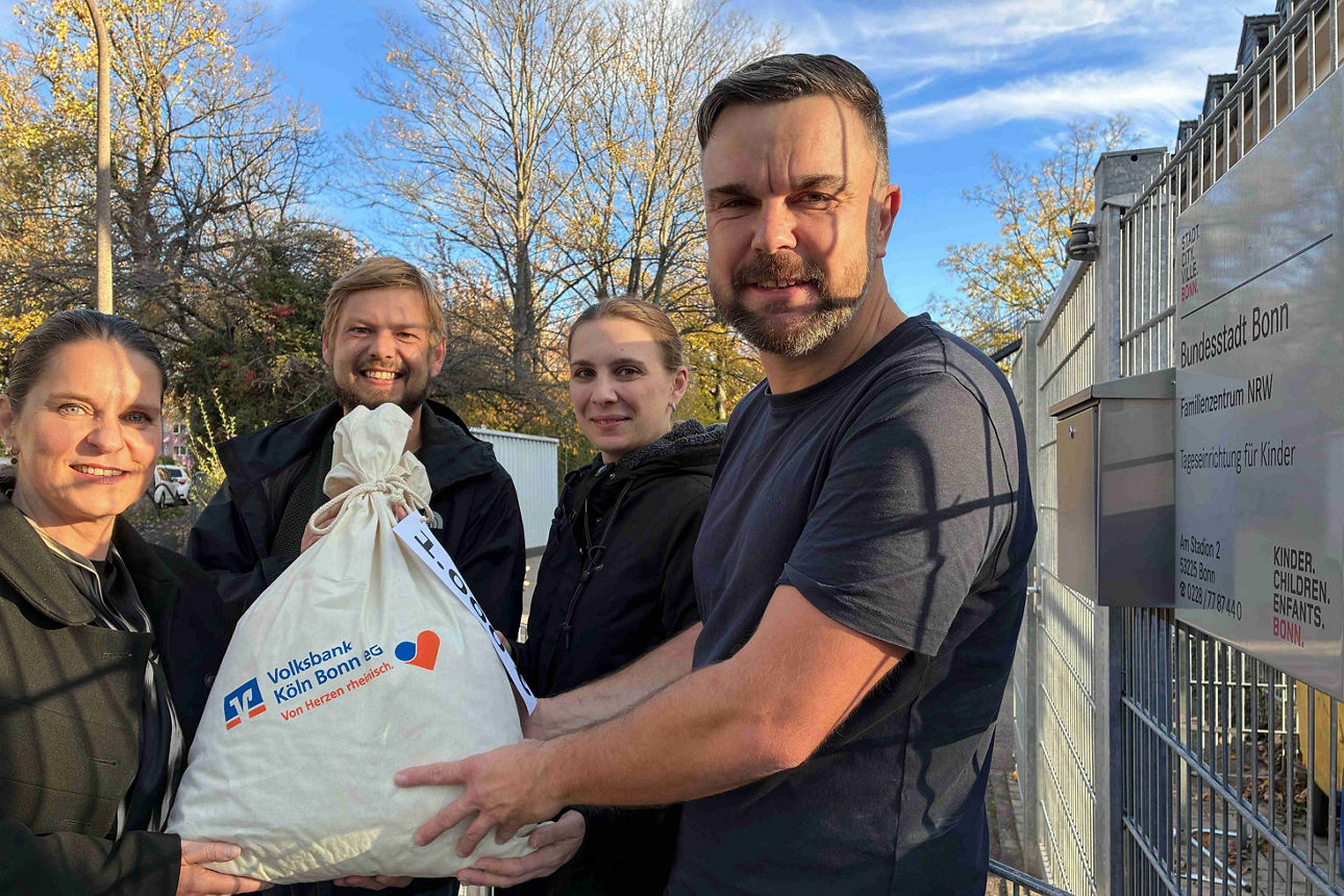 Sonja Krämer (Volksbank Köln Bonn) übergibt Dr. Sebastian Wien (Kinderhaus e.V.) einen symbolischen Geldsack