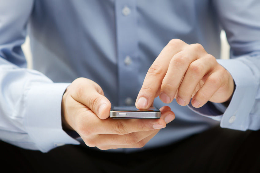 Mann tippt auf dem Smartphone