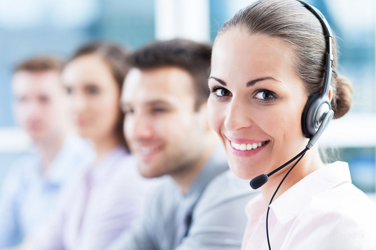 Frau mit Headset lächelt in die Kamera