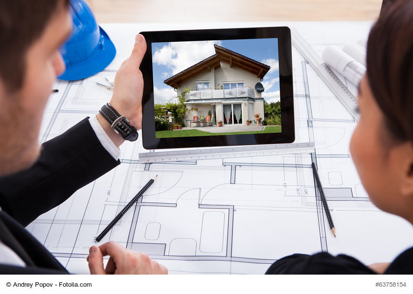 Zwei Berater halten ein Tablet in der Hand in dem ein Haus abgebildetet ist.