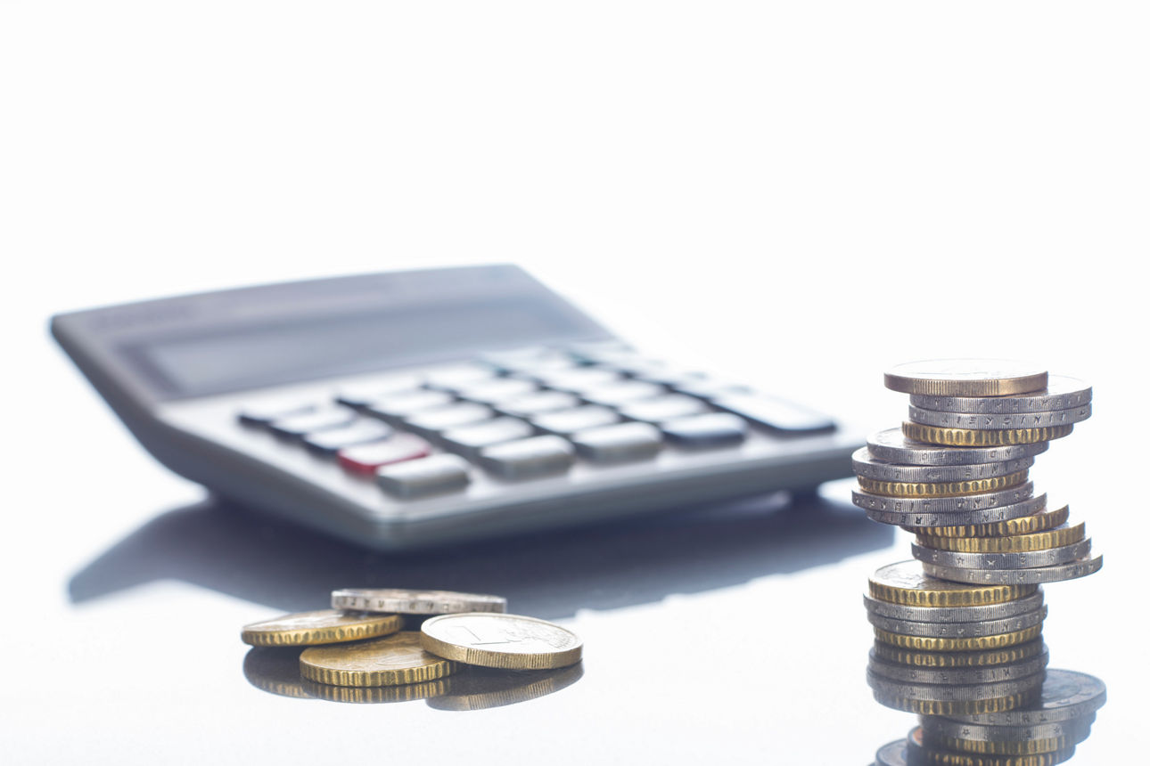 Finanzen, Euro, Euromünzen im Stapel und liegend auf spiegeldem Tisch und Taschenrechner, Hintergrund