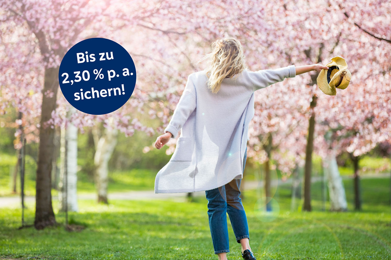 Frau freut sich über Frühling und Bäume mit Kirschblüte