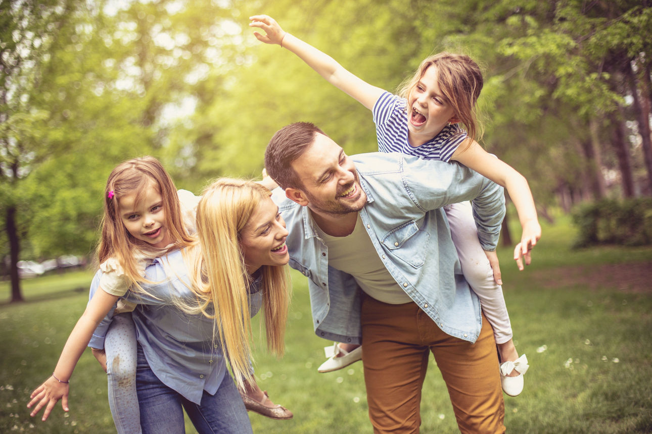 Glückliche Eltern mit ihren Töchtern im Park