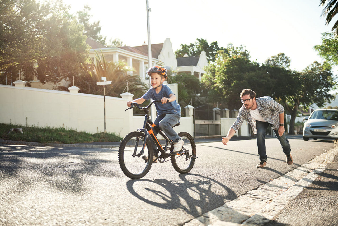 Vater lernt seinem Kind Fahrradfahren