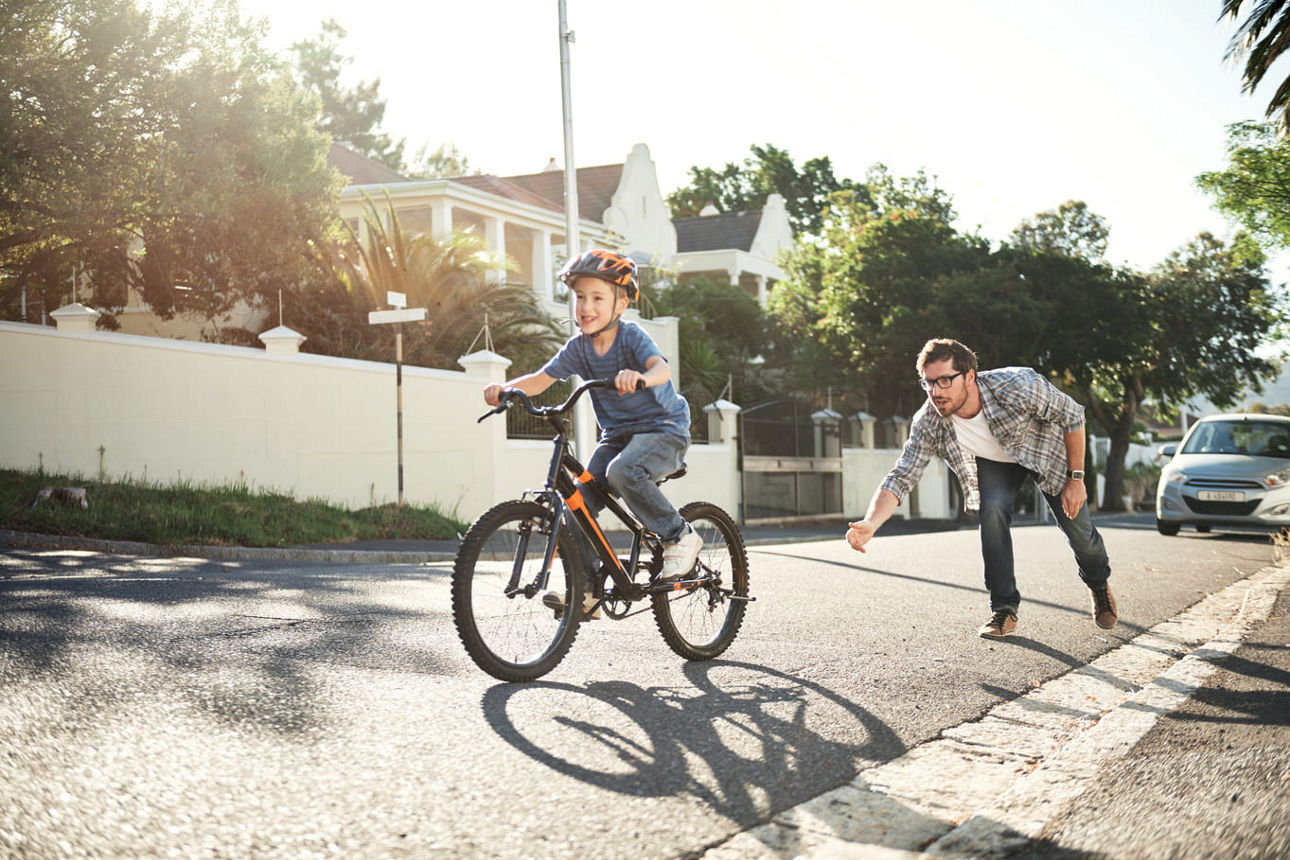 Vater übt Fahrradfahren mit seinem Kind