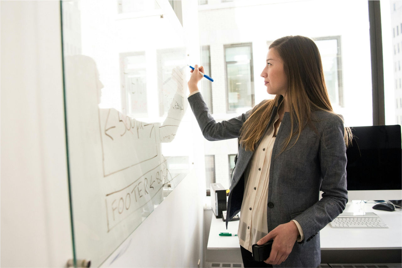 Eine Frau schreibt etwas an ein Whiteboard
